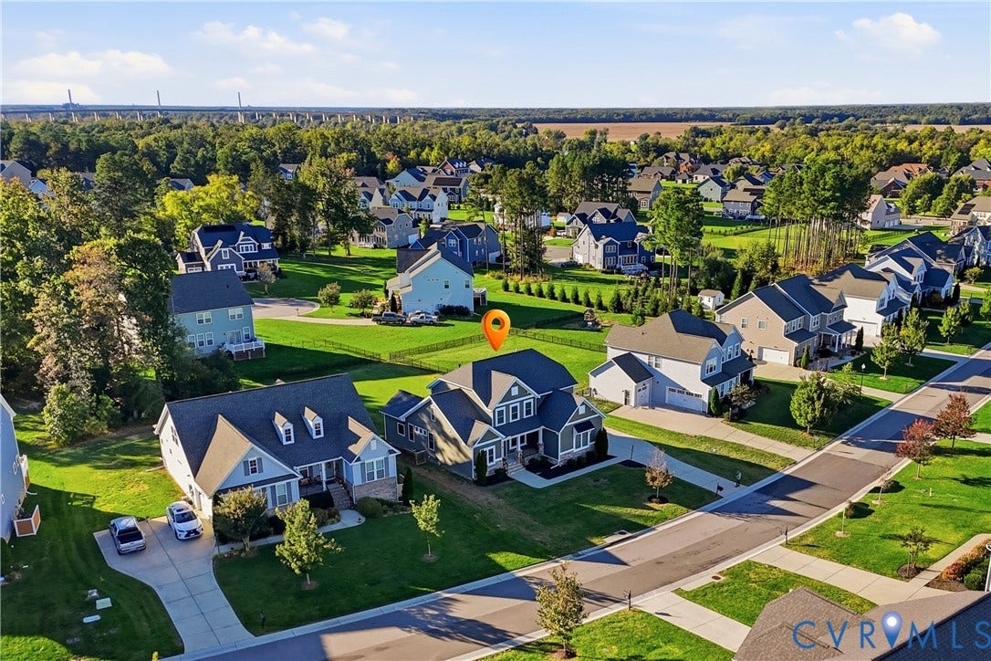 11936 Helmway Court, Chester, VA 23839 Aerial perspective of a multi-story residence featuring a dark shingle roof, a two-car attached garage, and a fenced rear yard