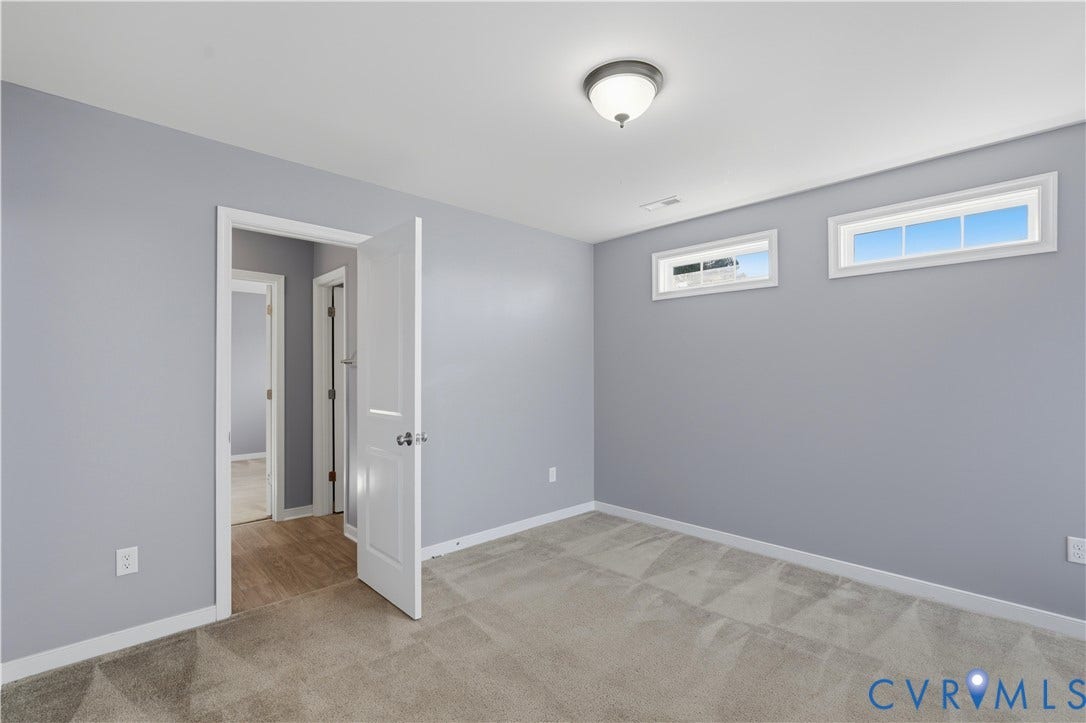 11936 Helmway Court, Chester, VA 23839 Bedroom #4 Neutral-toned interior space featuring light grey walls, wall-to-wall carpeting, two horizontal transom windows, and a classic flush-mount ceiling light fixture