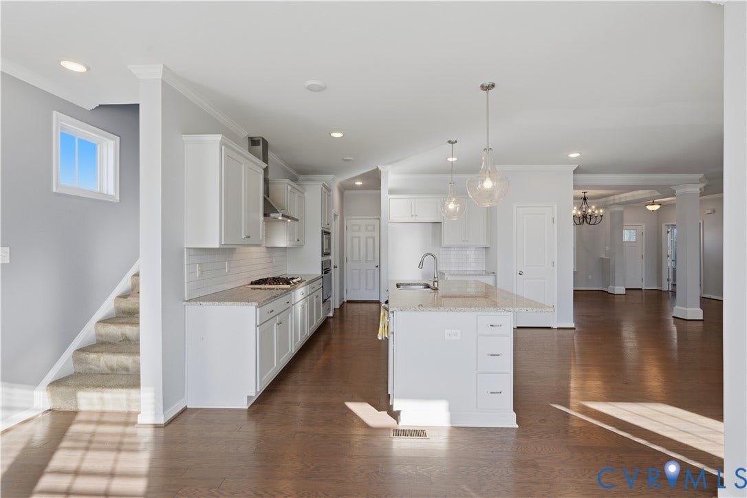 11936 Helmway Court, Chester, VA 23839 Kitchen featuring white shaker-style cabinetry, stone-surface countertops, a center island with undermount sink, pendant lighting, and wood-finish flooring