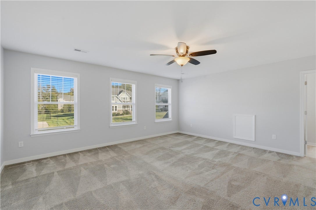 11936 Helmway Court, Chester, VA 23839 Upstairs Primary Bedroom or bedroom #2. Neutral-toned room featuring neutral wall-to-wall carpeting, three windows with horizontal blinds, and a central ceiling fan with integrated lighting
