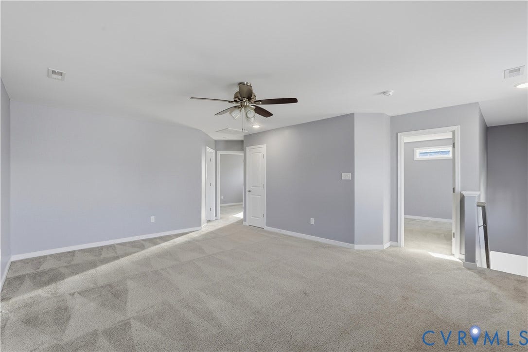 11936 Helmway Court, Chester, VA 23839 Interior space featuring neutral-toned carpeting, multi-panel doors, and a central ceiling fan with integrated lighting