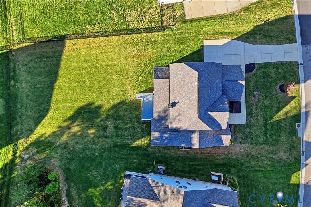 11936 Helmway Court, Chester, VA 23839 Aerial perspective of a multi-level residence featuring a multi-gabled shingle roof, a concrete driveway, and a spacious side lawn