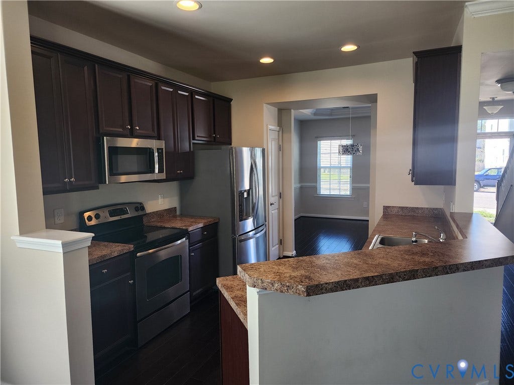 9031 Annex Lane, Mechanicsville, VA 23116 Kitchen featuring dark cabinetry, stainless steel appliances, speckled laminate countertops, recessed lighting, and wood-finish flooring