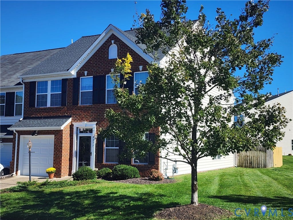 9031 Annex Lane, Mechanicsville, VA 23116 Multi-story brick facade featuring shuttered windows, a gabled roofline, single-car garage, and manicured lawn