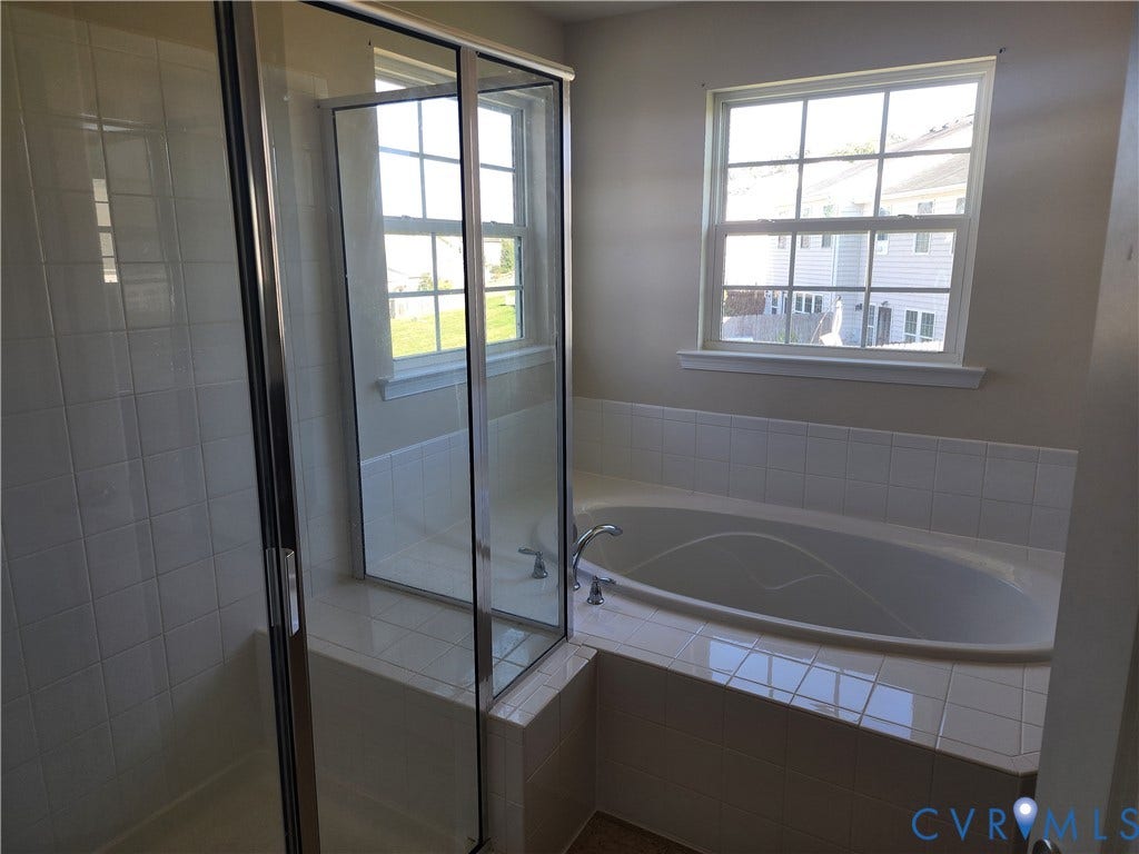 9031 Annex Lane, Mechanicsville, VA 23116 Bathroom featuring a glass-enclosed shower, built-in soaking tub with tiled surround, and dual pane windows