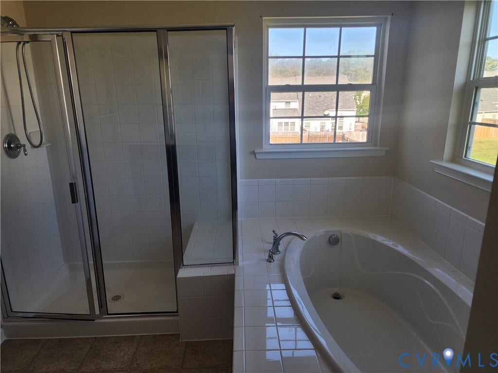 9031 Annex Lane, Mechanicsville, VA 23116 Oversized soaking tub with white tile surround, separate glass-enclosed shower, and dual multi-pane windows