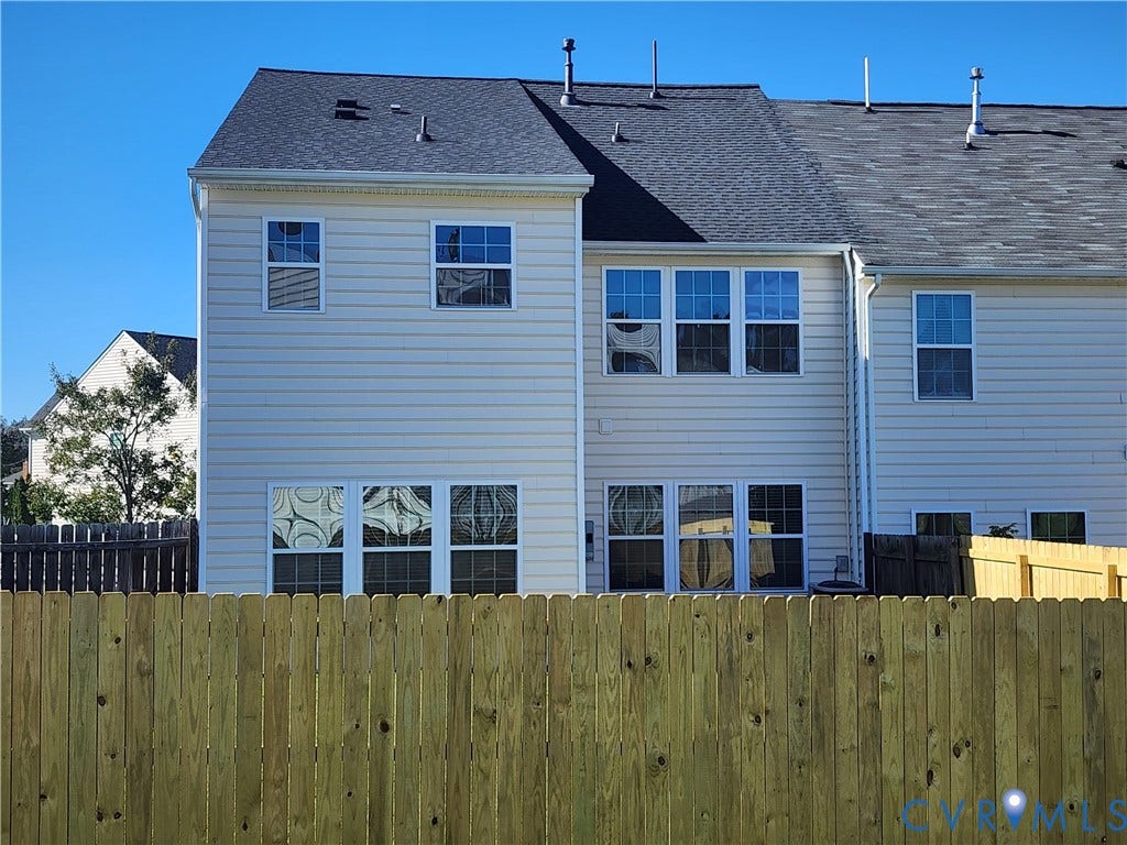 9031 Annex Lane, Mechanicsville, VA 23116 Two-story light-colored siding exterior with a shingled roof, multi-pane windows, and a privacy wood fence