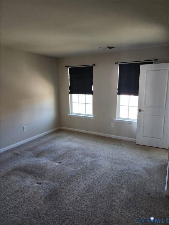 9031 Annex Lane, Mechanicsville, VA 23116 Neutral-toned interior room featuring wall-to-wall carpeting, two windows with muntin dividers, and a six-panel door with a brushed nickel lever