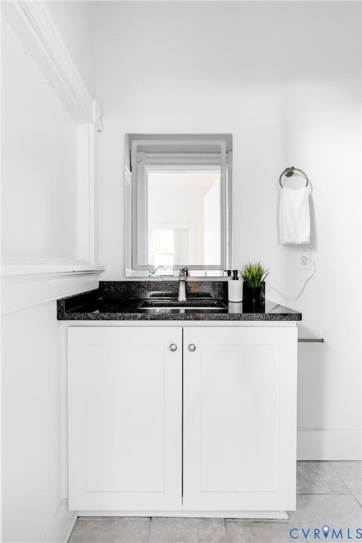 2005 Barton Avenue, Barton Heights, Richmond, VA 23222 White cabinetry vanity with a dark stone countertop, integrated undermount sink, chrome faucet, and rectangular wall-mounted mirror