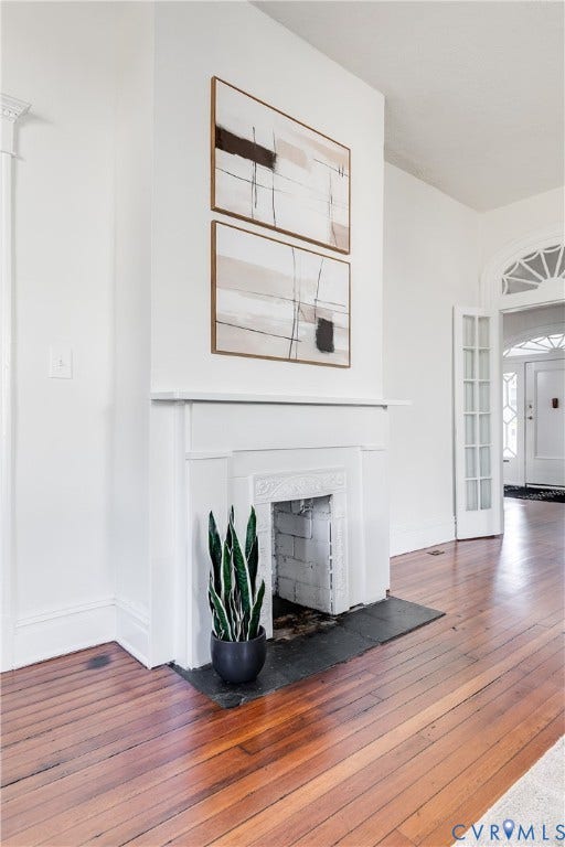 2005 Barton Avenue, Barton Heights, Richmond, VA 23222 Fireplace featuring a classic mantelpiece and a dark stone hearth, complemented by wood-finish flooring, high ceilings, and an arched transom window