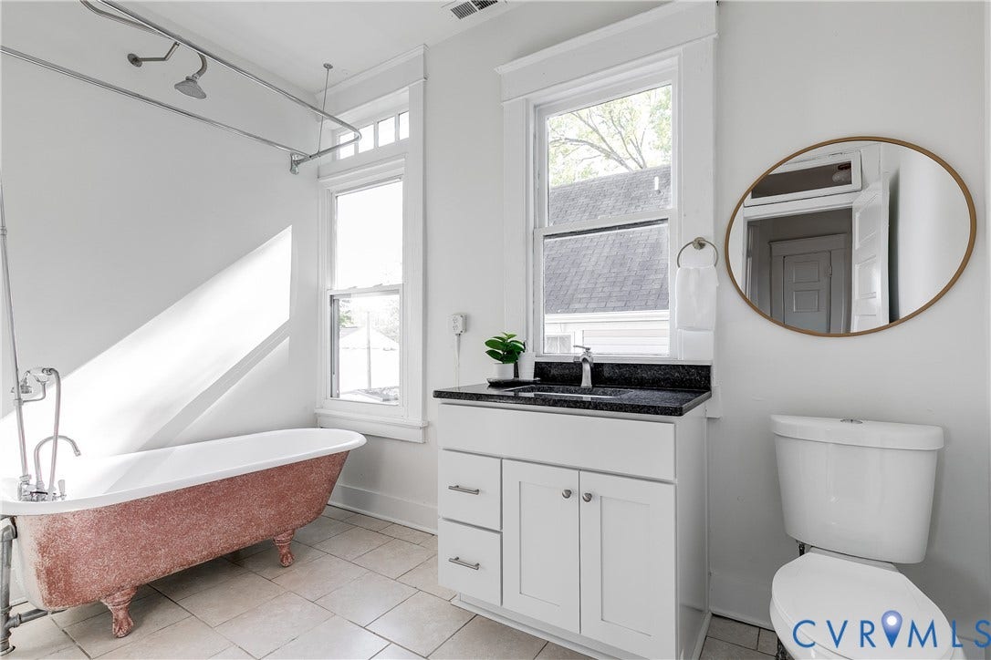 2005 Barton Avenue, Barton Heights, Richmond, VA 23222 Clawfoot soaking tub with exposed plumbing, white vanity cabinet with stone countertop, large oval mirror, and tile flooring