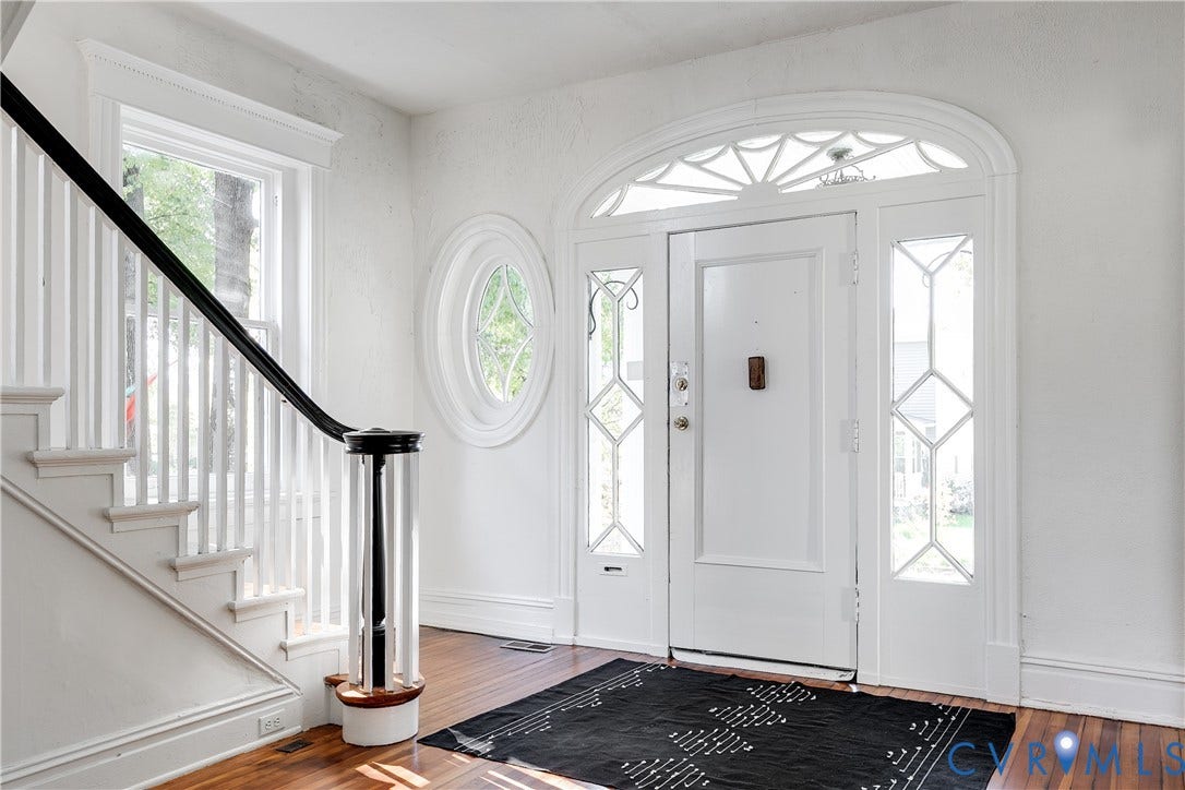 2005 Barton Avenue, Barton Heights, Richmond, VA 23222 Foyer featuring wood-finish flooring, a decorative arched transom window, a round accent window, and a staircase with a contrasting black handrail