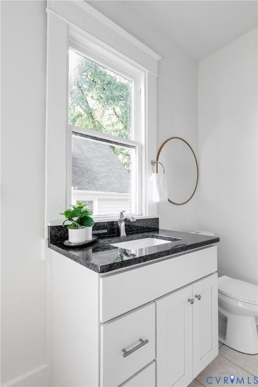 2005 Barton Avenue, Barton Heights, Richmond, VA 23222 White shaker-style cabinetry with a dark stone countertop, integrated rectangular sink, brushed metal faucet, and tall window with wide trim