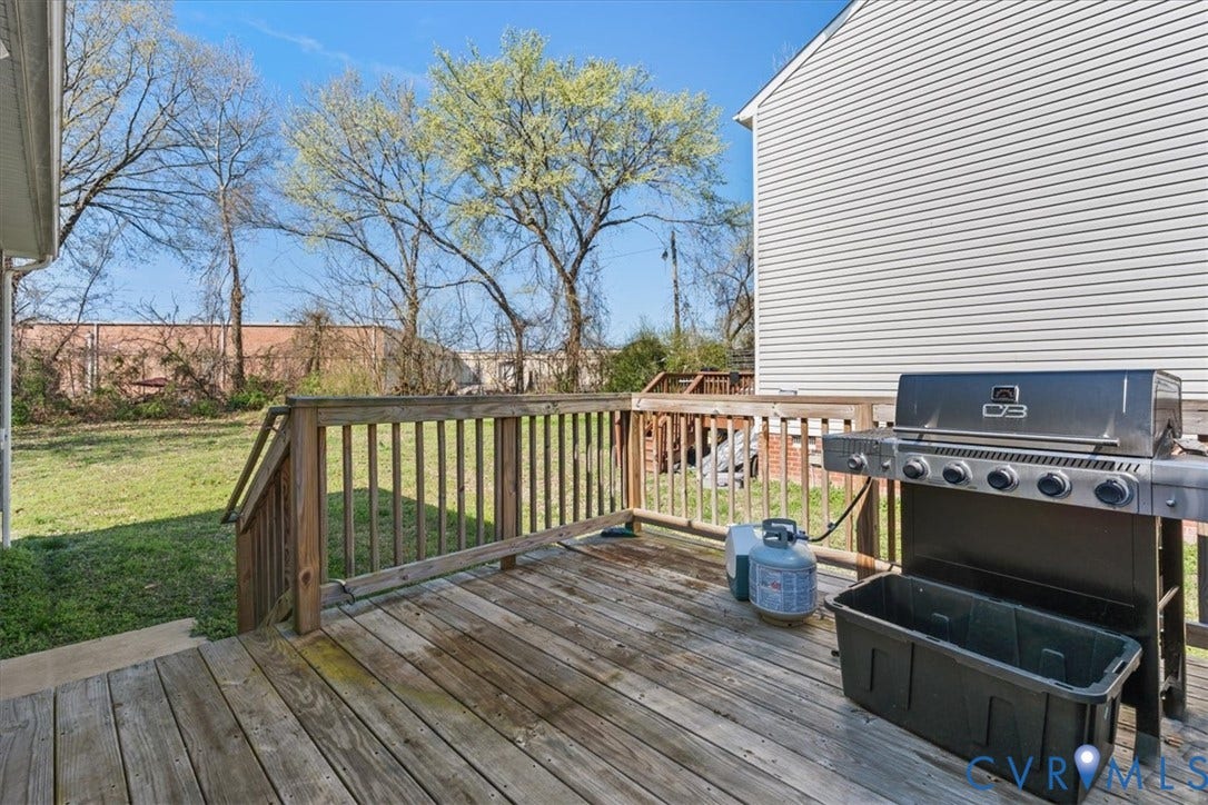 600 Highland Avenue, Hopewell, VA 23860 Rear wooden deck featuring horizontal planking, vertical wood railing, and stair access to the grounds