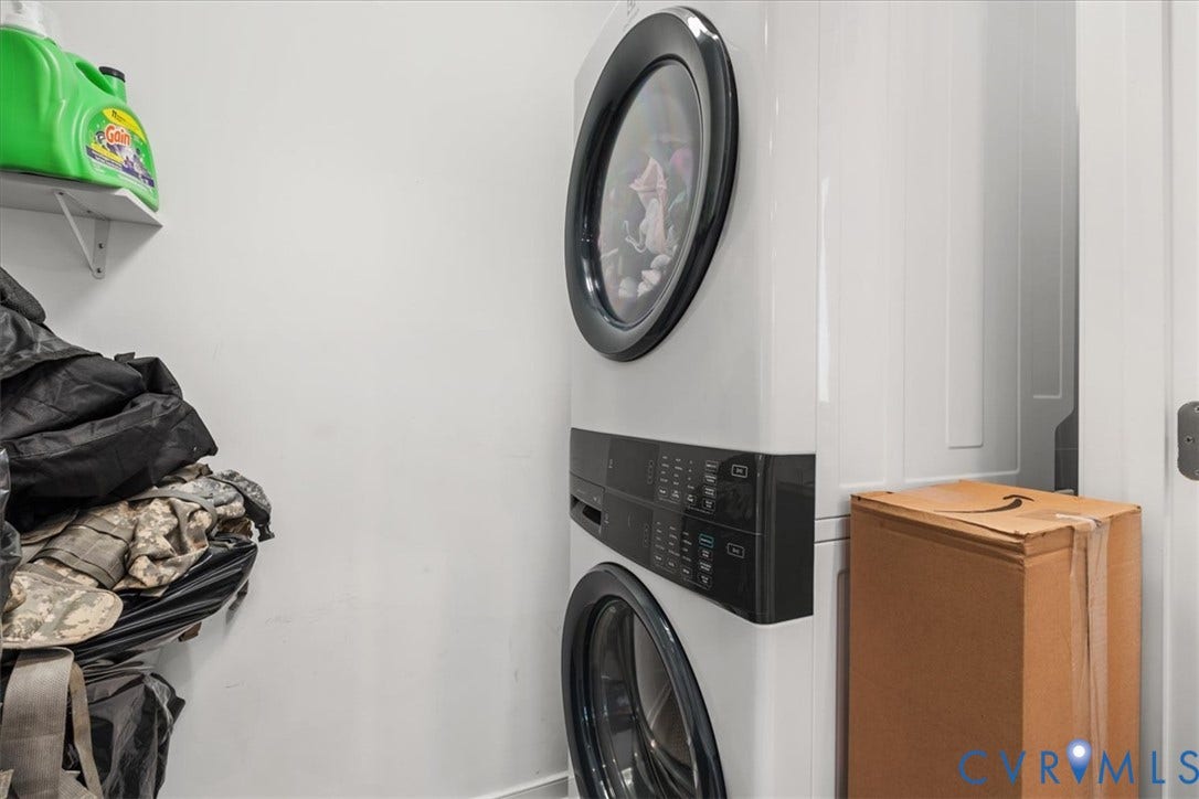 600 Highland Avenue, Hopewell, VA 23860 Stackable white front-load washer and dryer unit with black digital interface panels, accompanied by a fixed wall-mounted storage shelf