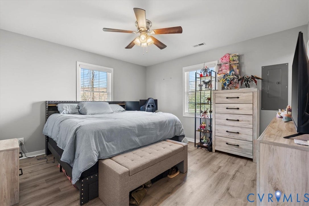 600 Highland Avenue, Hopewell, VA 23860 Room featuring neutral-toned walls, wood-finish flooring, two windows, and a ceiling fan with integrated light fixture