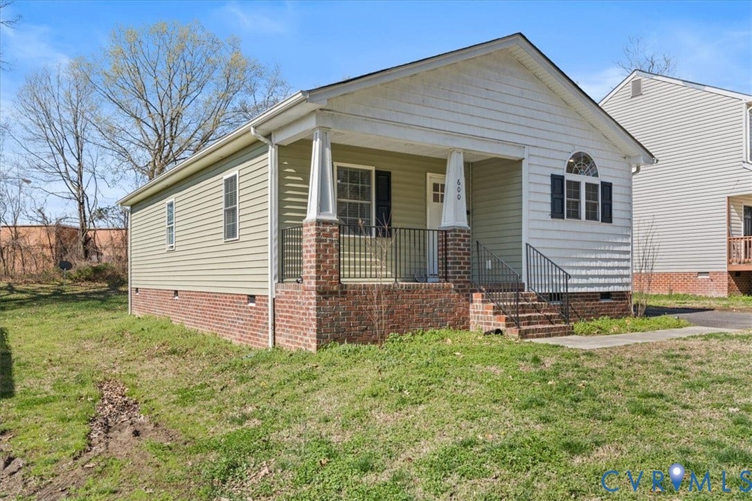 600 Highland Avenue, Hopewell, VA 23860 Single-story residence featuring horizontal siding, a brick foundation, a covered front porch with tapered columns, and arched decorative window detailing