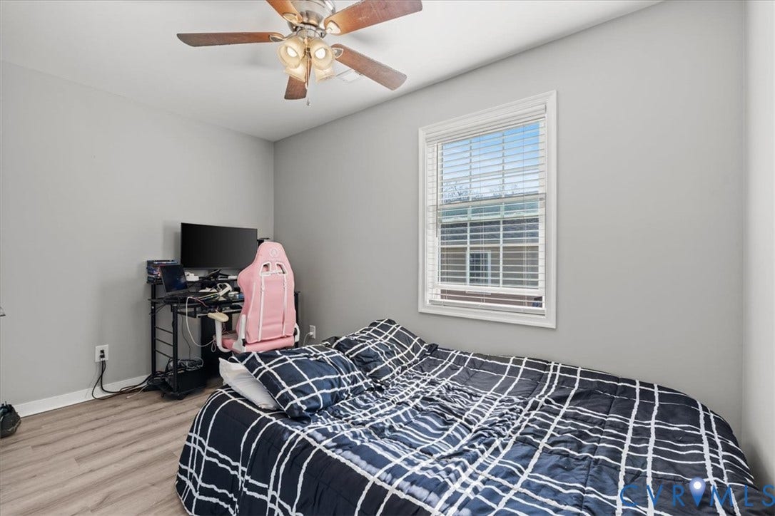 600 Highland Avenue, Hopewell, VA 23860 Neutral interior room featuring wood-finish flooring, a ceiling fan with integrated lighting, and a window with horizontal blinds