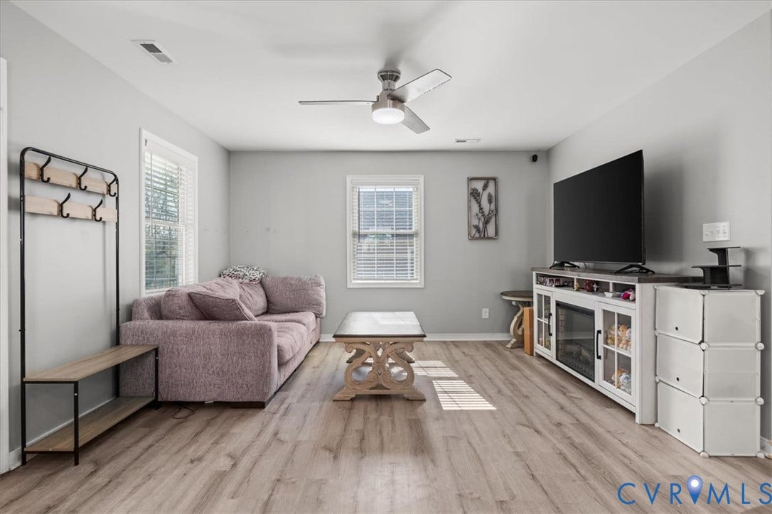 600 Highland Avenue, Hopewell, VA 23860 Neutral-toned interior featuring wood-finish flooring, dual windows with blinds, and a brushed nickel ceiling fan with integrated lighting