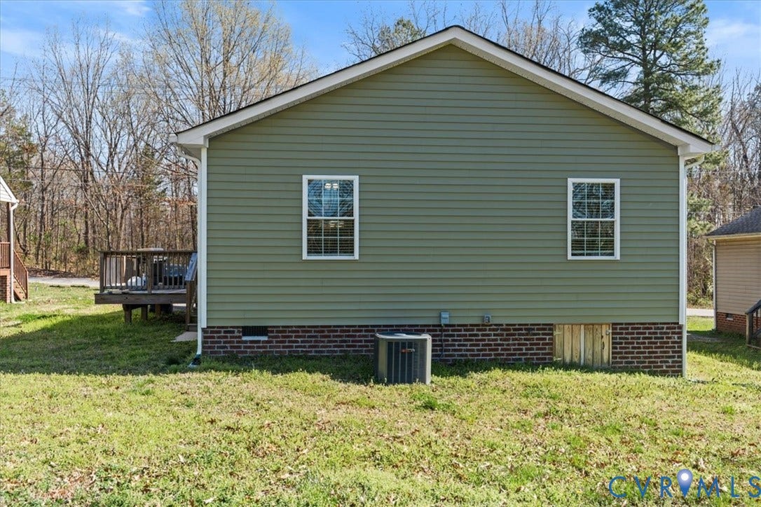 600 Highland Avenue, Hopewell, VA 23860 Exterior featuring horizontal siding, a brick foundation, gabled roofline, double-hung windows, and an attached wood deck