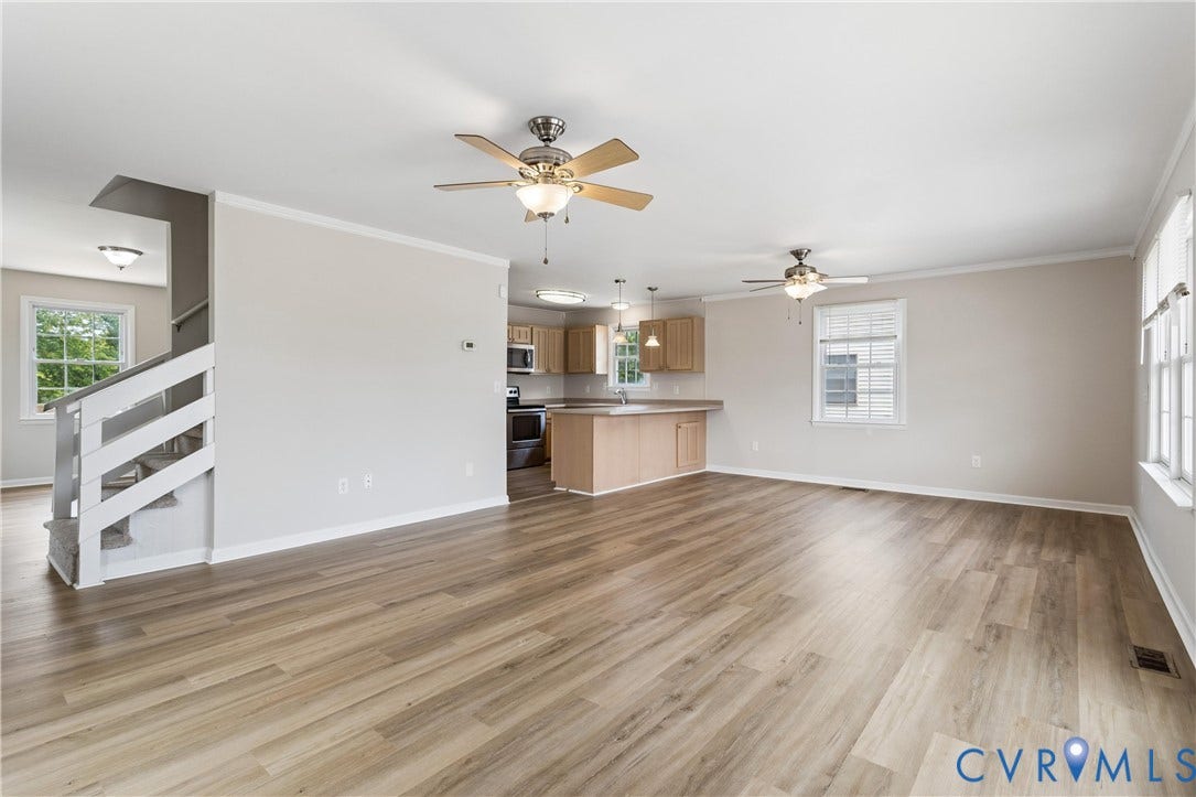 11 Bonita Drive, Hampton, VA 23664 Open interior featuring wood-finish flooring, two ceiling fans, multi-pane windows, and a kitchen peninsula with integrated cabinetry