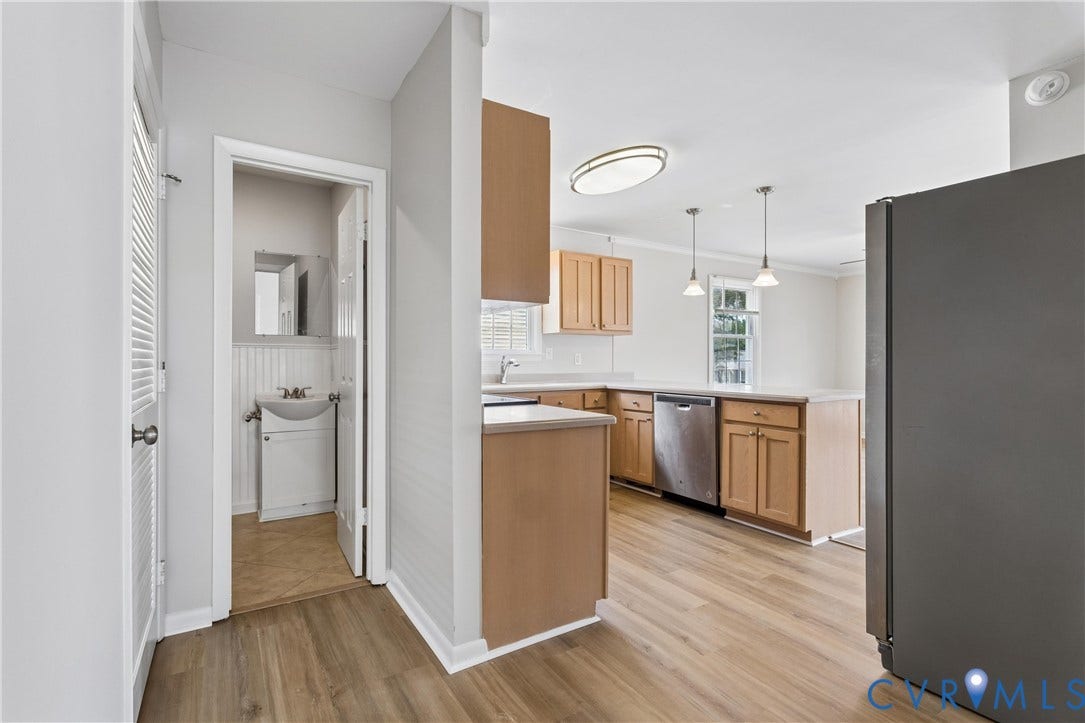 11 Bonita Drive, Hampton, VA 23664 Kitchen featuring wood-finish cabinetry, stainless steel dishwasher, and neutral countertops, complemented by wood-finish flooring and pendant lighting