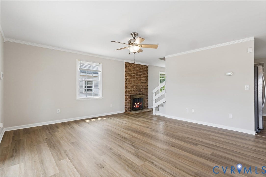 11 Bonita Drive, Hampton, VA 23664 Interior space featuring wood-finish flooring, a floor-to-ceiling brick fireplace, ceiling-mounted fan, multi-pane window, and white handrail staircase