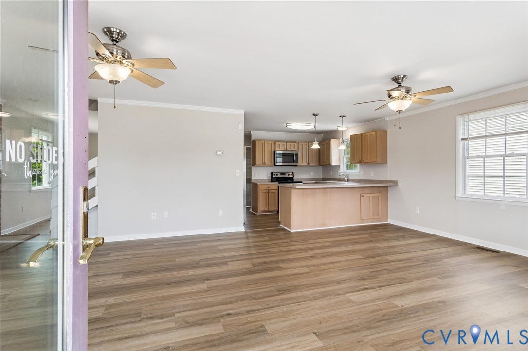 11 Bonita Drive, Hampton, VA 23664 Open-concept living space featuring wood-finish flooring, recessed lighting, dual ceiling fans, and a kitchen equipped with wood cabinetry and a peninsula counter