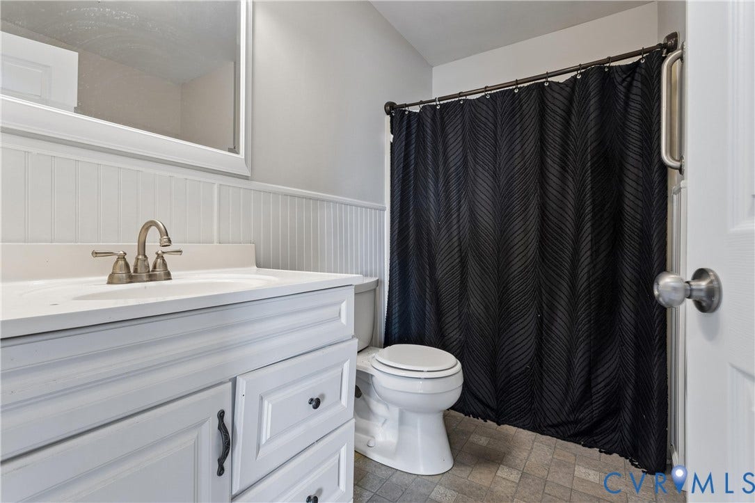 11 Bonita Drive, Hampton, VA 23664 Bathroom featuring a white vanity with integrated basin, beadboard wall paneling, framed wall mirror, and neutral tile flooring