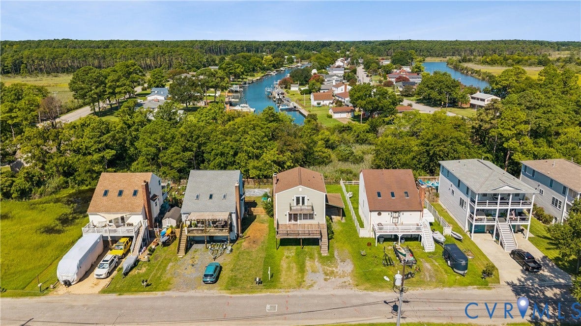 11 Bonita Drive, Hampton, VA 23664 Aerial perspective of waterfront properties featuring direct canal access, elevated multi-level decks, exterior staircase entryways, and asphalt shingle roofing