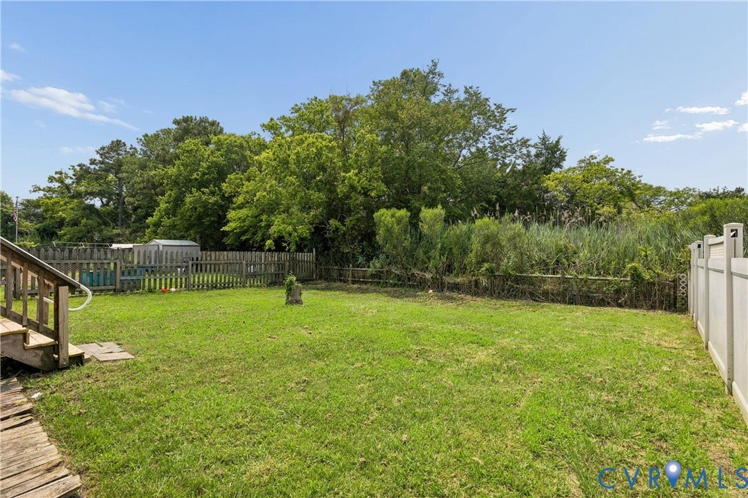 11 Bonita Drive, Hampton, VA 23664 Rear yard featuring a grass lawn, perimeter wood fencing, a white vinyl privacy fence, and mature trees