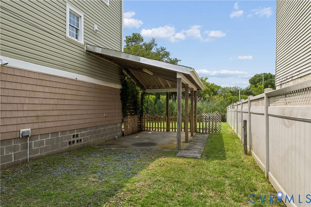 11 Bonita Drive, Hampton, VA 23664 Covered concrete patio with overhead support structure, vinyl siding, decorative shingle accents, and perimeter vinyl fencing