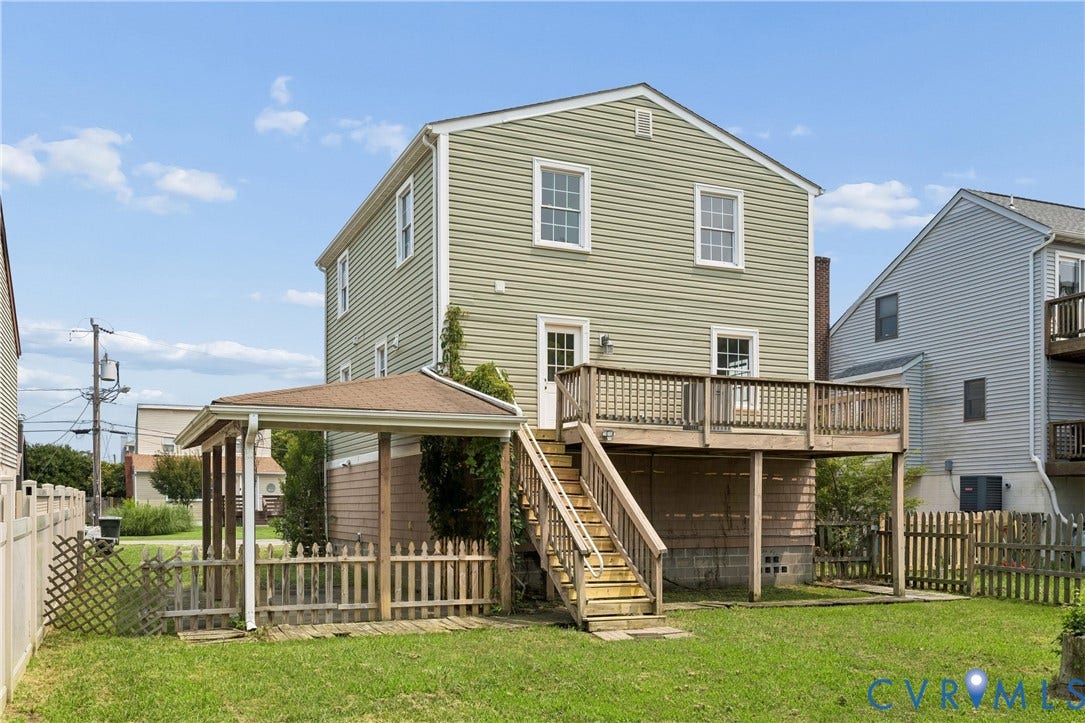 11 Bonita Drive, Hampton, VA 23664 Exterior featuring green vinyl siding, an elevated wood deck with railing, a covered ground-level patio, a wooden staircase, and a fenced yard