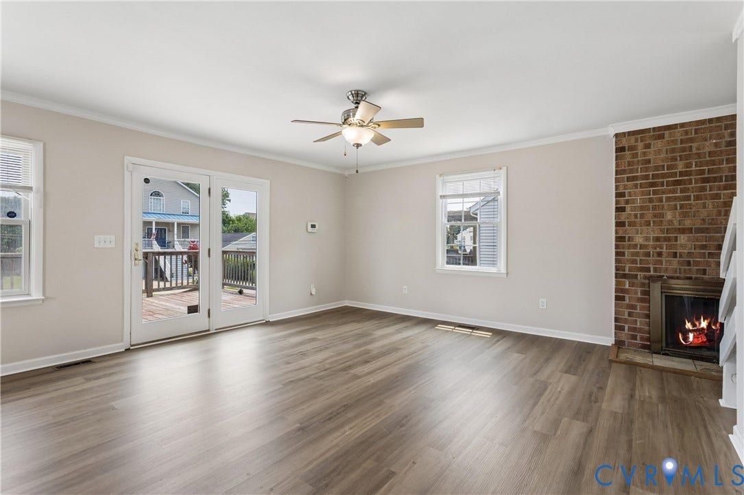 11 Bonita Drive, Hampton, VA 23664 Living area featuring wood-finish flooring, a brick fireplace with a built-in insert, double-pane windows, and double-glass doors opening to an exterior deck