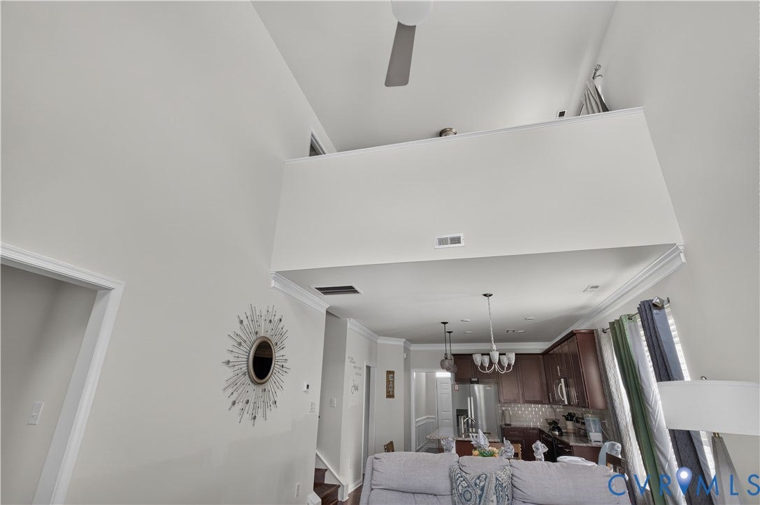 2230 Nightfall Drive, Chesterfield, VA 23236 Vaulted ceilings, mezzanine overlook, stainless steel refrigerator, dark wood cabinetry, and crown molding