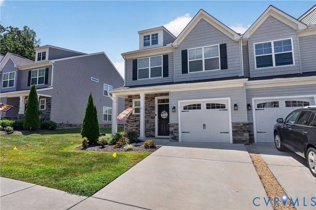 2230 Nightfall Drive, Chesterfield, VA 23236 Multi-level exterior featuring light gray horizontal siding, stone veneer accents, double-gable roofline, and two attached garages