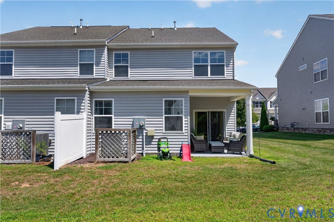 2230 Nightfall Drive, Chesterfield, VA 23236 Gray vinyl siding exterior featuring a covered rear patio, white vinyl privacy fencing, and lattice-enclosed mechanical units