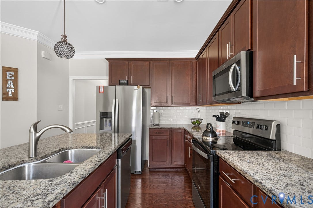 2230 Nightfall Drive, Chesterfield, VA 23236 Kitchen featuring stained wood cabinetry, stone countertops, white subway tile backsplash, stainless steel appliances, and wood-finish flooring