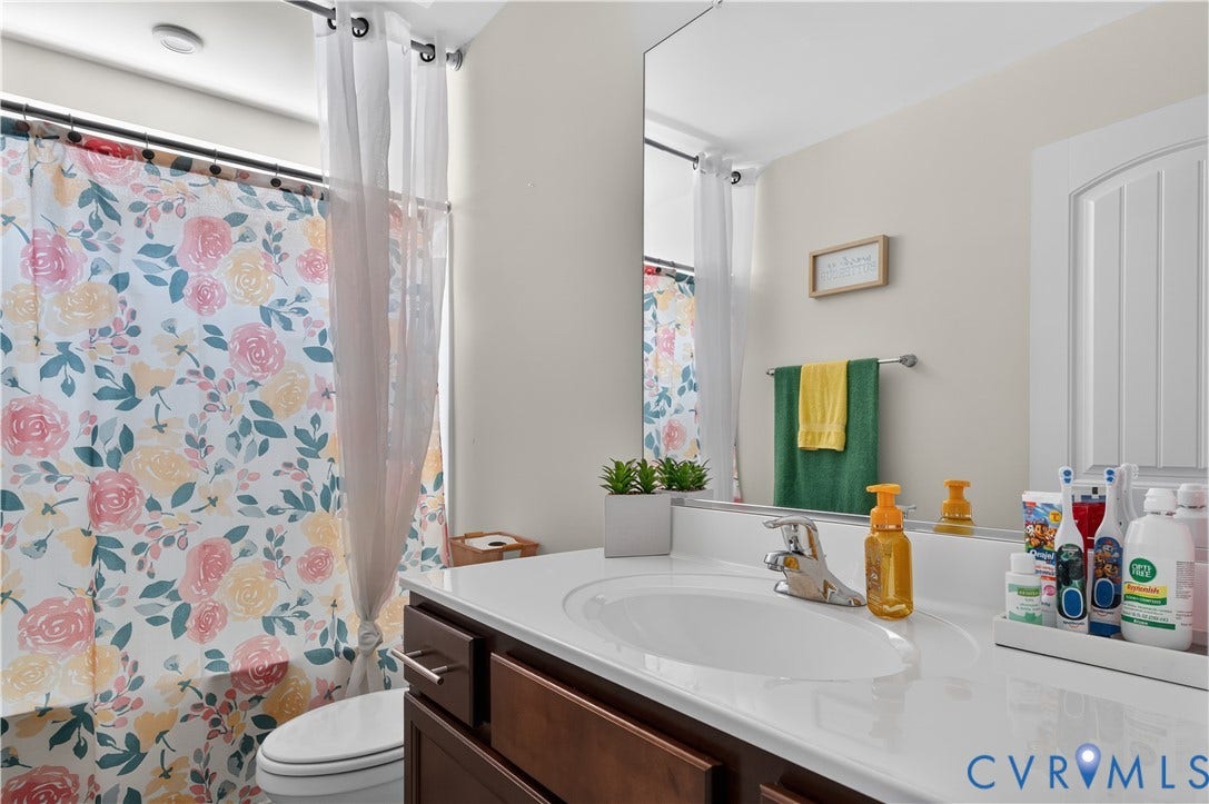 2230 Nightfall Drive, Chesterfield, VA 23236 Bathroom featuring a vanity with a white countertop and integrated sink, polished chrome faucet, large wall-mounted mirror, and a built-in bathtub