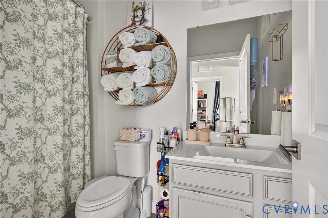 3900 Maze Runner Drive, #102, Chesterfield, VA 23112 Bathroom featuring a vanity with shaker-style cabinetry, an integrated rectangular sink, and a chrome faucet, complemented by a large frameless mirror