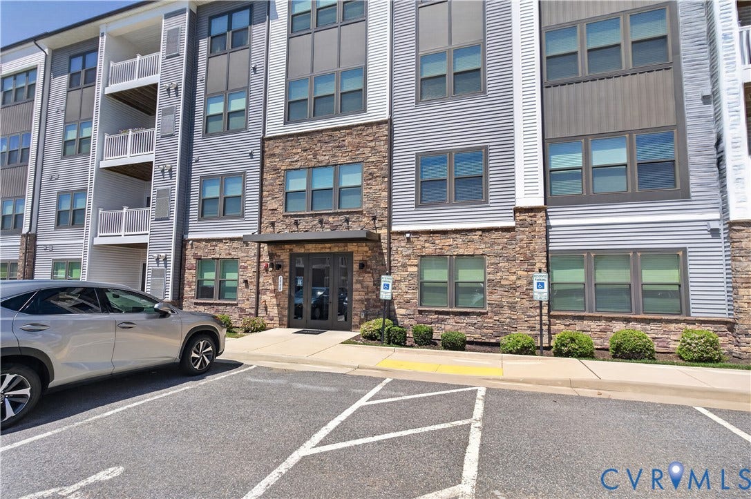 3900 Maze Runner Drive, #102, Chesterfield, VA 23112 Multi-story building exterior featuring stone masonry cladding, horizontal siding, private balconies with white railings, and an entry canopy