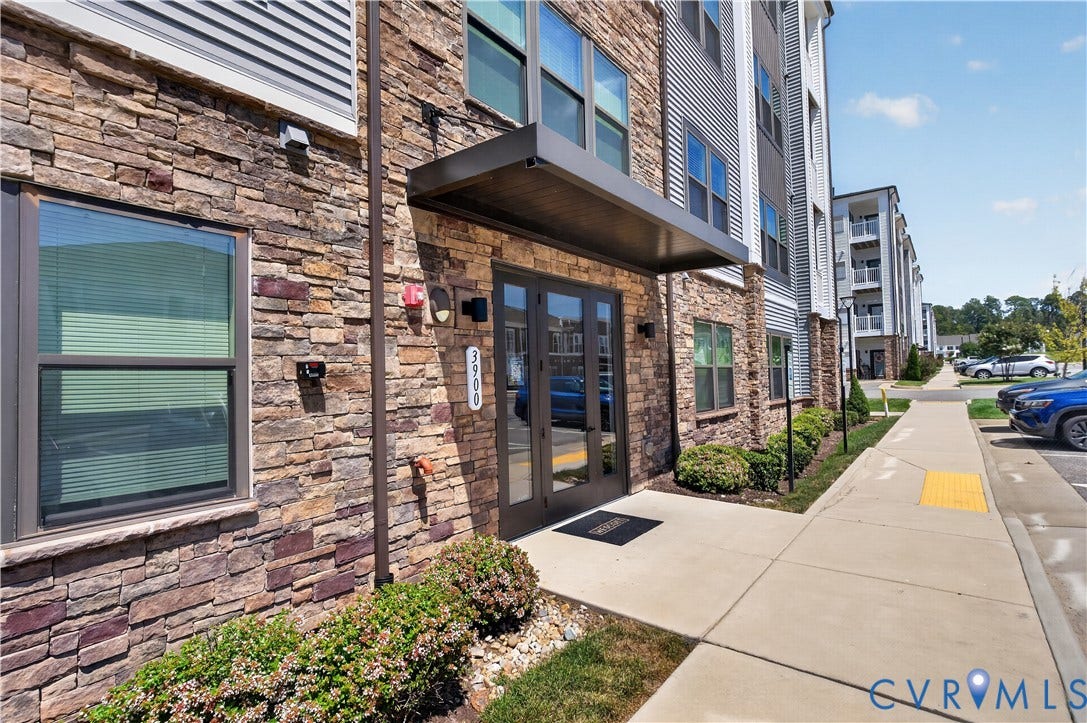 3900 Maze Runner Drive, #102, Chesterfield, VA 23112 Exterior featuring stone veneer facade, metal-framed glass double-door entrance, and a modern metal cantilevered awning
