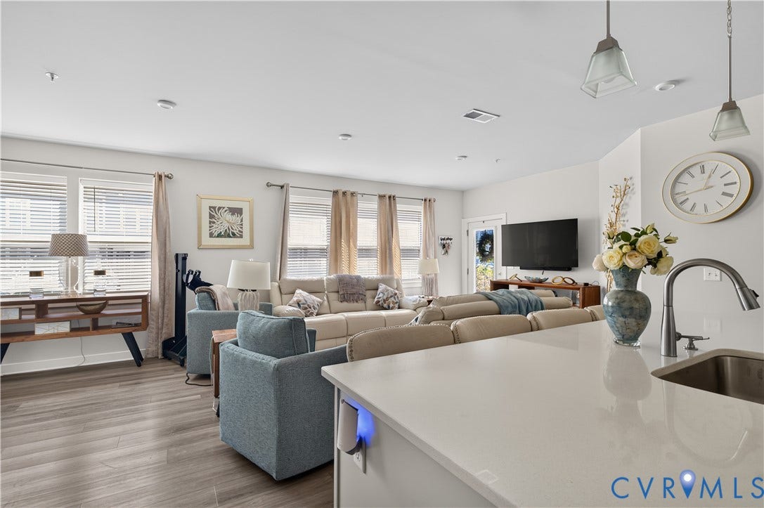 3900 Maze Runner Drive, #102, Chesterfield, VA 23112 Open-concept interior featuring wood-finish flooring, recessed lighting, and a kitchen island with stone-surface countertop and undermount stainless steel sink