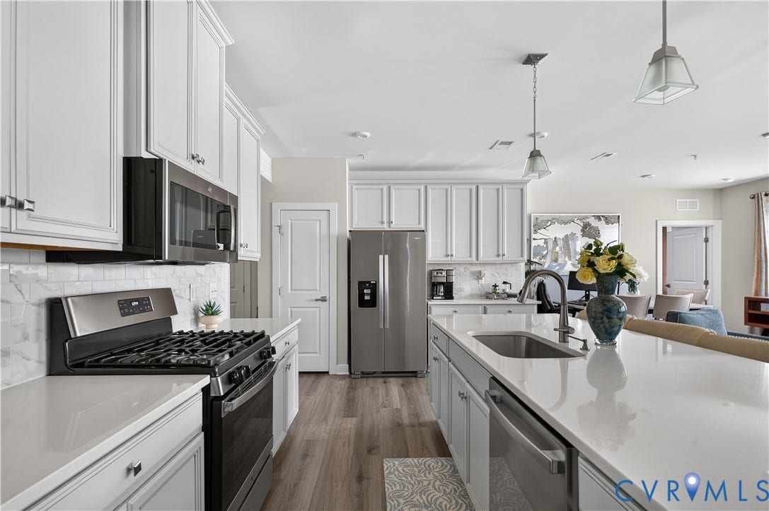 3900 Maze Runner Drive, #102, Chesterfield, VA 23112 Kitchen featuring white shaker-style cabinetry, quartz countertops, subway tile backsplash, stainless steel appliances, and wood-finish flooring