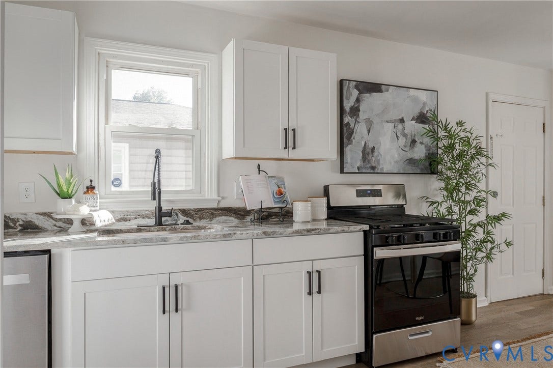 5429 Blueridge Avenue, Fulton, Richmond, VA 23231 Kitchen featuring white Shaker-style cabinetry, matte black hardware, stone-patterned countertops, a high-arc faucet, and a stainless steel range