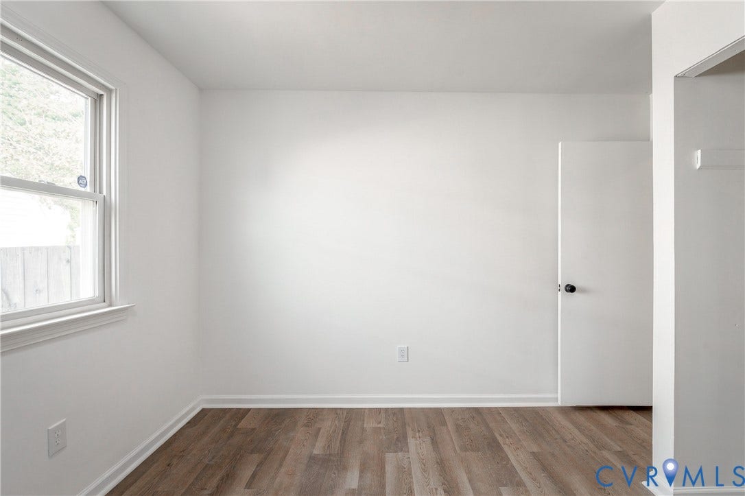 5429 Blueridge Avenue, Fulton, Richmond, VA 23231 Neutral interior space featuring wood-finish flooring, crisp white walls, a single-hung window, and a paneled interior door with a round knob