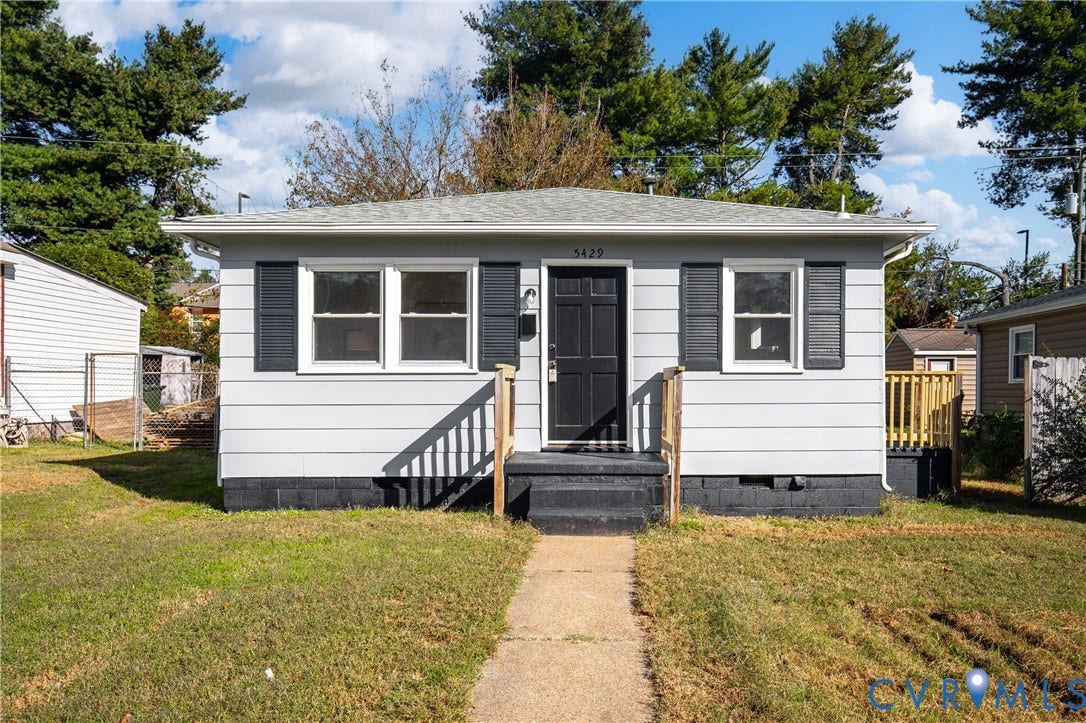 5429 Blueridge Avenue, Fulton, Richmond, VA 23231 Single-story exterior featuring light gray horizontal siding, dark decorative shutters, a six-panel entry door, and a concrete pathway