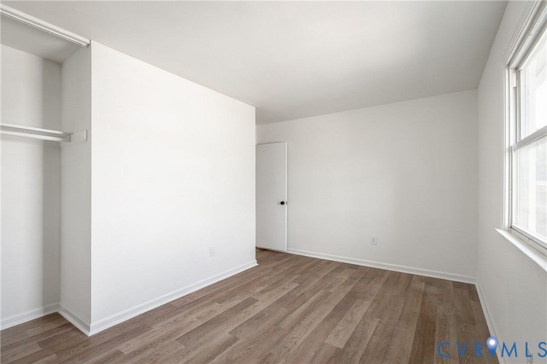 5429 Blueridge Avenue, Fulton, Richmond, VA 23231 Interior space featuring wood-finish flooring, white walls, a built-in closet with shelving, and a dual-pane window