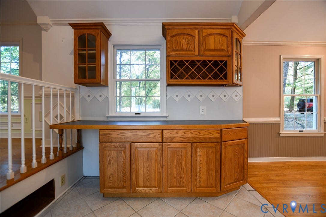 3486 Venter Road, Minors Pines, Aylett, VA 23009 Custom wood cabinetry with integrated wine rack, dark countertop, ceramic tile flooring, and white spindle railing