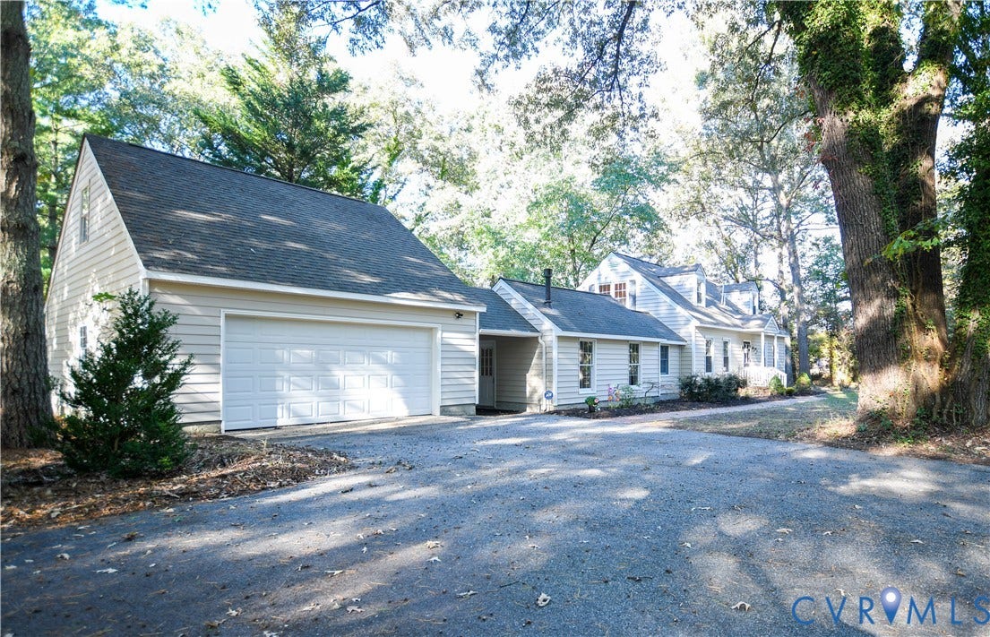 3486 Venter Road, Minors Pines, Aylett, VA 23009 Exterior facade featuring horizontal siding, a two-car garage, and an expansive gravel driveway situated amidst mature trees